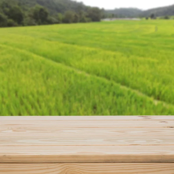 Wood table top with green fields background — Stock Photo, Image