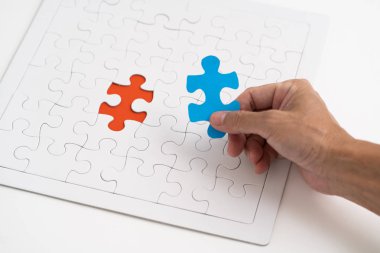 Kırmızı yapboz arka planda mavi bir yapboz tutuyordu.