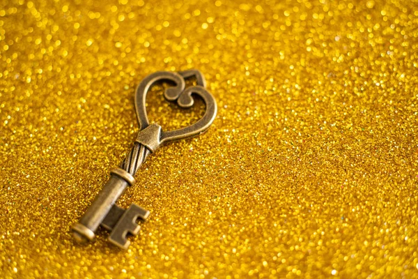 Vintage key on gold glitter background