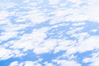 Bulutların ve mavi gökyüzünün üzerinde uçuyor