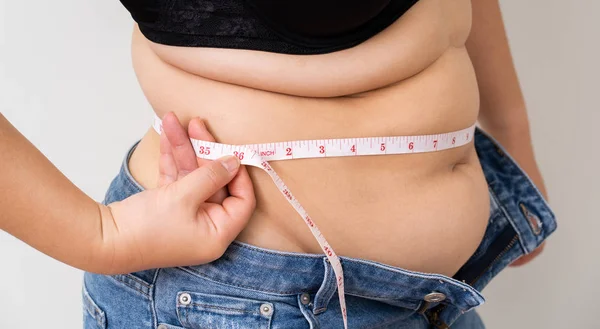 Overweight women with tape measuring her belly — Stock Photo, Image