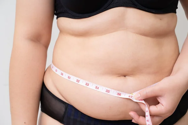 Избыточный вес женщин с лентой измерения ее живота — стоковое фото