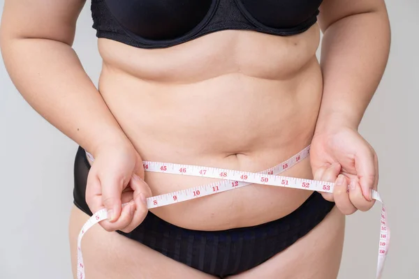 Overweight women with tape measuring her belly — Stock Photo, Image