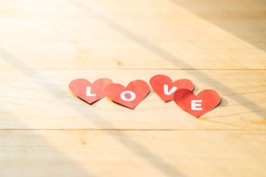 Ahşap zeminde dört kırmızı kalp