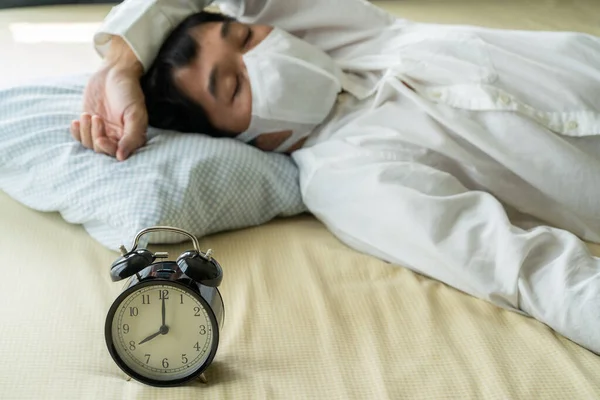 수술용 마스크를 착용하고 시계로 침대에서 아시아 사업가 — 스톡 사진