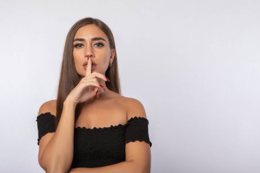 Güzel kız sessizlik için parmağını dudaklarına koydu.