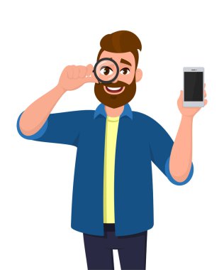 Şık genç adam büyüteçle bakıyor ve boş akıllı telefon, cep telefonu ya da cep telefonu gösteriyor. Hippi modasına uygun kişi elinde büyüteç ya da lens tutuyor. Vektör karikatürde erkek karakter çizimi.