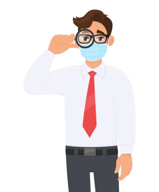 Genç iş adamı tıbbi maske takıyor ve büyüteçten bakıyor. Gözlüklü ve elinde büyüteç olan modaya uygun biri. Modern yaşam tarzı. Vektör karikatürde erkek karakter çizimi tasarımı.