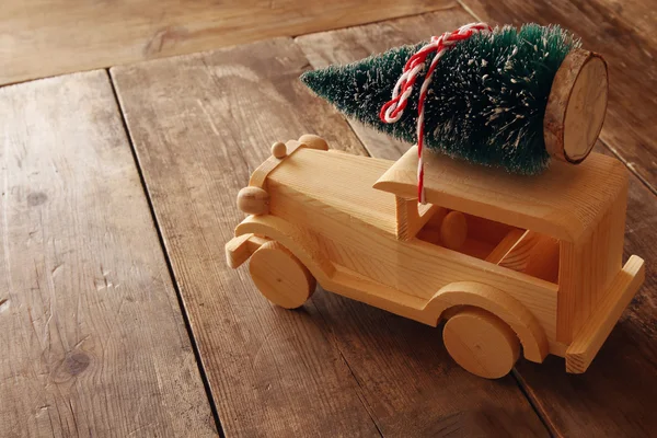 Wooden car carrying Christmas tree — Stock Photo, Image