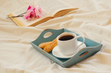 yatakta romantik kahvaltı ve açık kitap