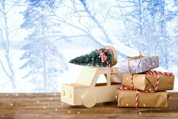 Coche que lleva un árbol de Navidad en frente de landsca invierno mágico —  Fotos de Stock