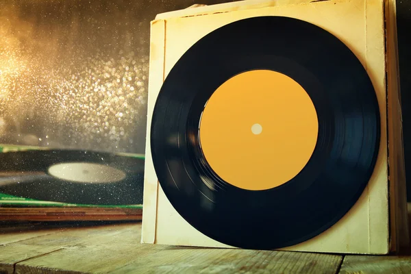 Old records on wooden table with glitter background — Stock Photo, Image