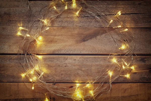 Christmas warm gold garland lights on wooden background — Stock Photo, Image