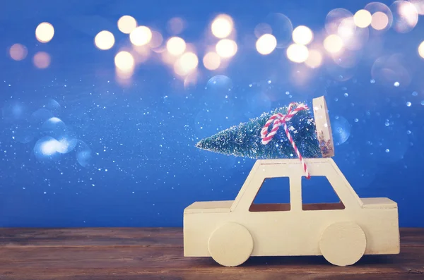 Ξύλινα αυτοκίνητο που μεταφέρουν ένα χριστουγεννιάτικο δέντρο στο τραπέζι — Φωτογραφία Αρχείου