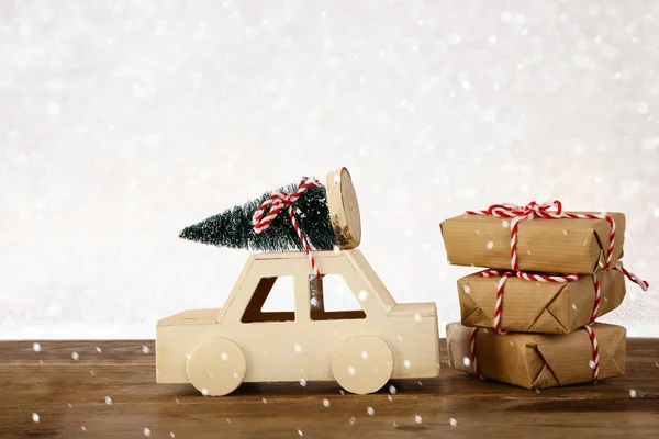 Coche que lleva un árbol de Navidad en frente de fondo de brillo —  Fotos de Stock