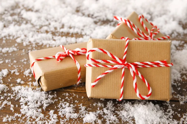 Imagen de cajas de regalo hechas a mano sobre una mesa de madera nevada — Foto de Stock