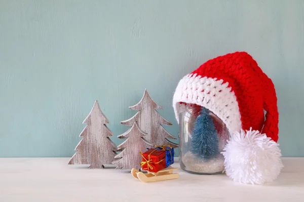 Χαριτωμένο πλεκτό καπέλο santa στο βάζο κτιστών με Χριστουγεννιάτικο δέντρο — Φωτογραφία Αρχείου