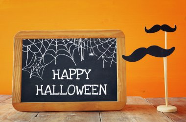 Cadılar Bayramı kavramı. Kağıt bıyık yanındaki yazı tahtası