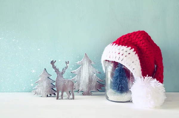 Χαριτωμένο πλεκτό καπέλο santa στο βάζο κτιστών με Χριστουγεννιάτικο δέντρο — Φωτογραφία Αρχείου