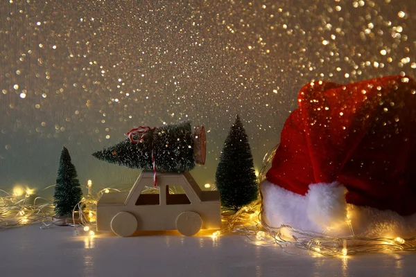 Low key image of wooden car carrying a christmas tree — Stock Photo, Image