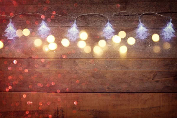 Guirnalda de árbol de Navidad luces sobre fondo de madera — Foto de Stock