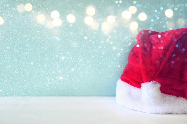 Santa claus red hat on wooden table. Glitter overlay — Stock Photo, Image