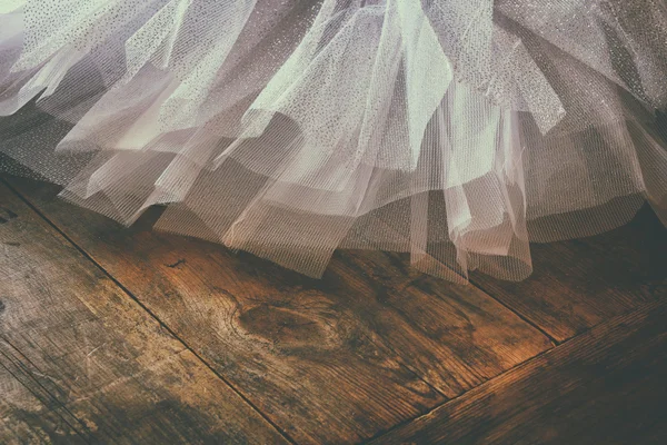 White ballet tutu on wooden floor. Retro filtered — Stockfoto