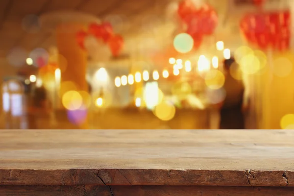 Ξύλινο τραπέζι μπροστά από το εστιατόριο θολά φώτα — Φωτογραφία Αρχείου