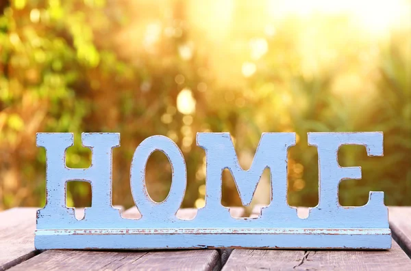 Vintage sign with the word HOME over wooden table — Stock fotografie