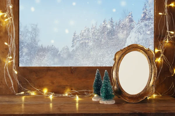 A karácsonyi fények és üres vintage képkeret régi ablakpárkányon — Stock Fotó