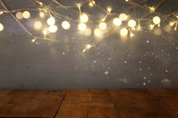 クリスマス温かみのあるゴールドのガーランド ライトの前で空のテーブル — ストック写真