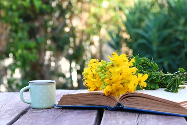 Altes Buch, Tasse Kaffee neben Feldblumen — Stockfoto