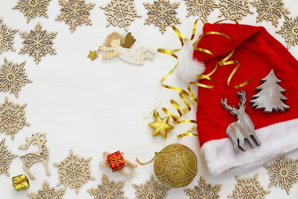 Weihnachtsmann mit rotem Hut neben Holzdekorationen — Stockfoto