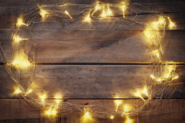 Árvore de Natal guirlanda luzes no fundo de madeira — Fotografia de Stock