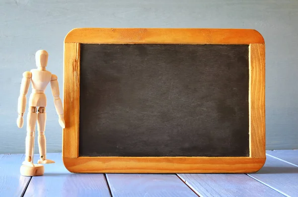 Wooden mannequin and chalkboard — Stock Photo, Image