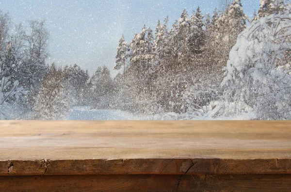 Empty wooden table in front of dreamy winter landscape