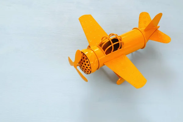 Immagine di retrò giallo metallo giocattolo aereo sopra tavolo di legno — Foto Stock