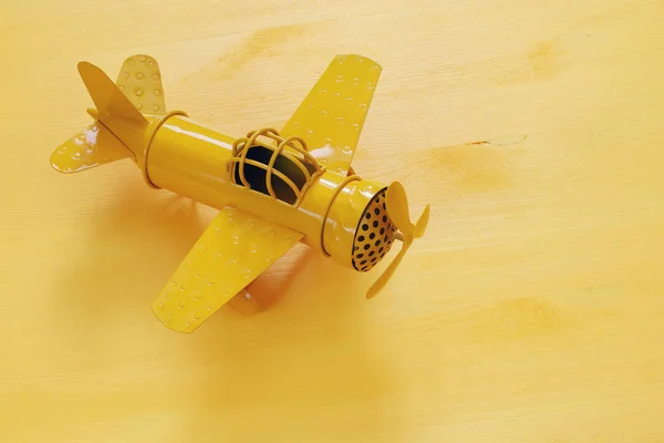 Immagine di retrò giallo metallo giocattolo aereo sopra tavolo di legno — Foto Stock