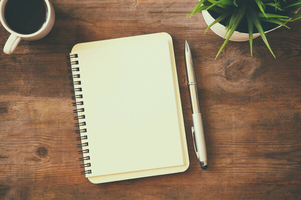 open notebook with blank pages next to cup of coffee