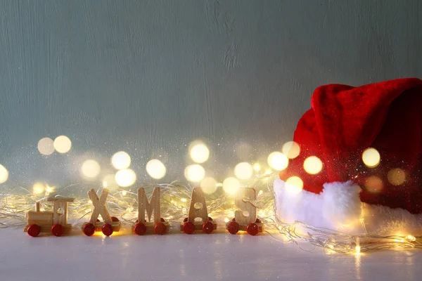 Garland lights bredvid santa hatt och trä bokstäver — Stockfoto