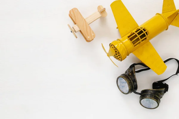 Vue du dessus de l'avion jouet jaune vintage et des lunettes pilotes — Photo
