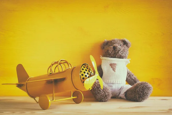 Винтажный игрушечный самолет и милый плюшевый мишка — стоковое фото