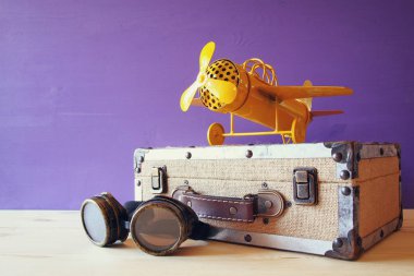 Vintage oyuncak uçak ve pilot gözlük yanındaki eski çanta