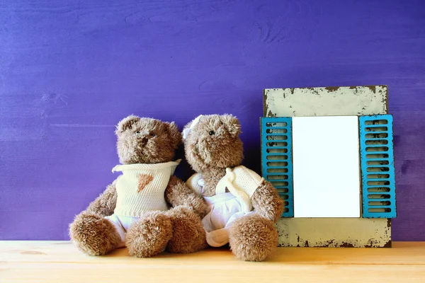 Foto de una linda pareja de osos de peluche al lado del marco vacío — Foto de Stock