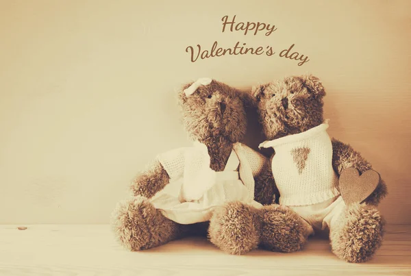 Valentines day concept. Couple of cute teddy bears holding heart, sitting on wooden table — Stock Photo, Image