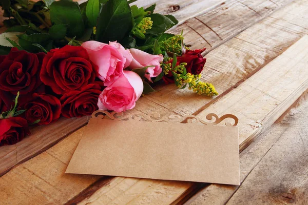 Mooi boeket rozen naast lege brief — Stockfoto