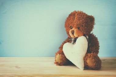 Oturma ve bir kalp tutan şirin ayıcık