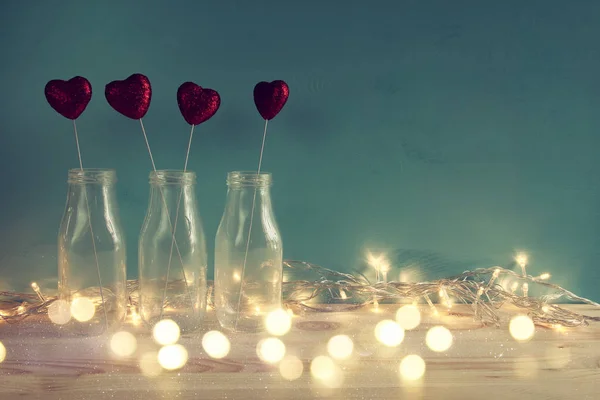 Coeurs scintillants dans les vases en verre sur une table en bois — Photo
