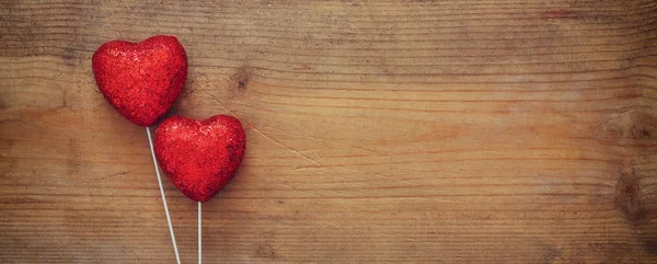 Couple of red glitter hearts on wooden background — Stock Photo, Image