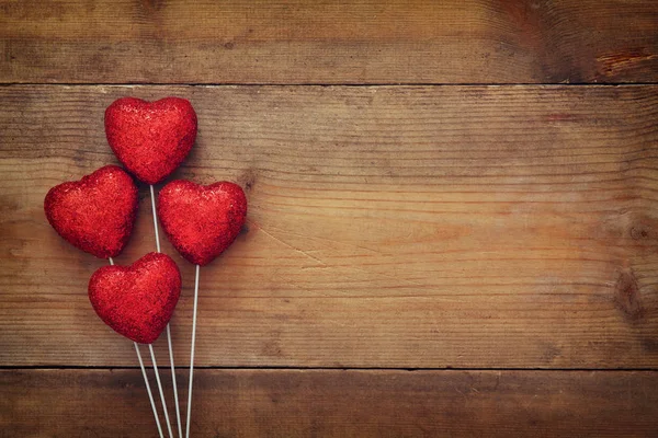 Corazones de purpurina roja sobre fondo de madera —  Fotos de Stock